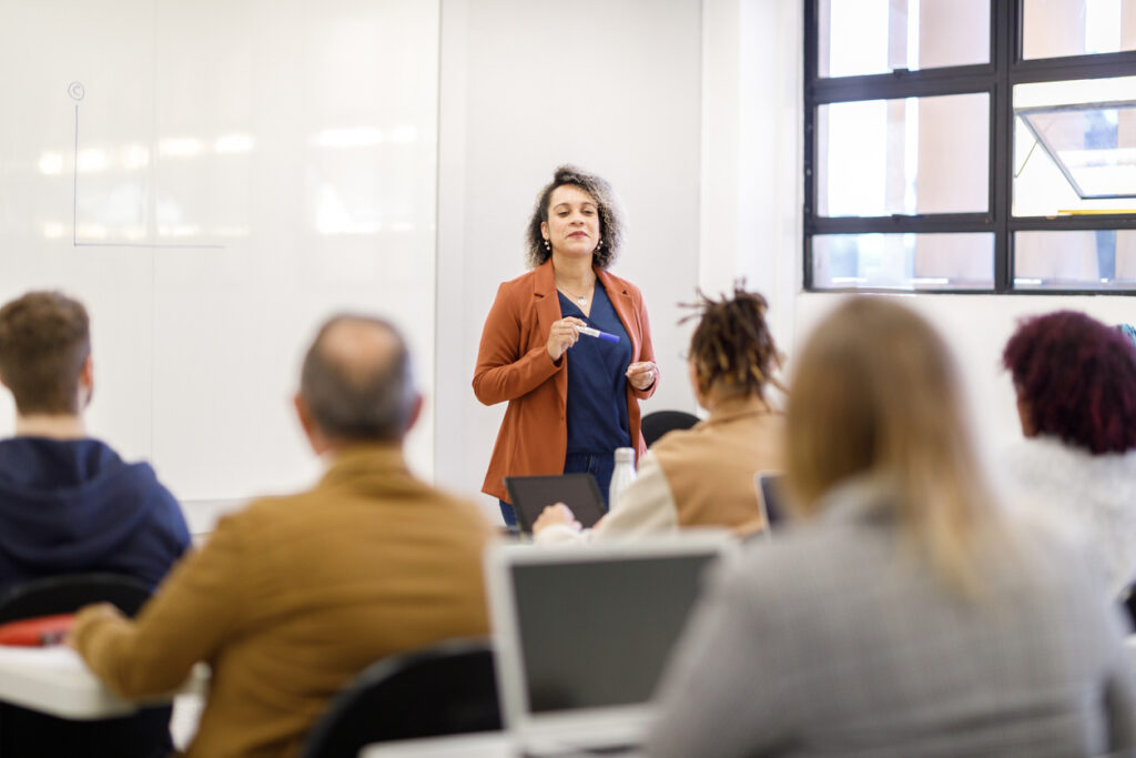 Female university professor teaching in a full classroom